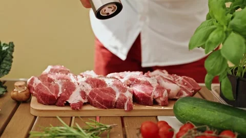 Close-up of a chef's hand grinding black pepper on the delicious and juicy meat Stock Footage 248969376