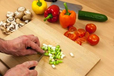 Close up of a chefs hands chopping some salad onions Stock Photos