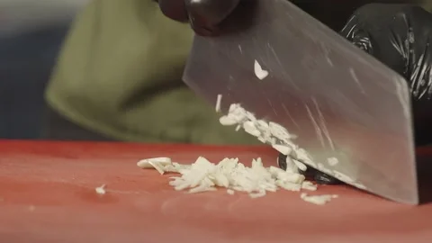Close-up of a chef's hands cutting garlic into small pieces Stock Footage 232618732
