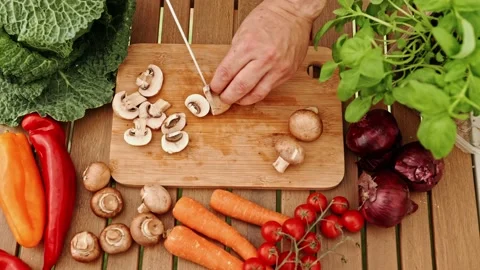 Close-up with chef's hands cutting mushrooms on a wooden board. Stock Footage 201139702