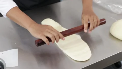 Close-up of a chef's hands flattening soft Japanese bread dough Stock Footage 296045763