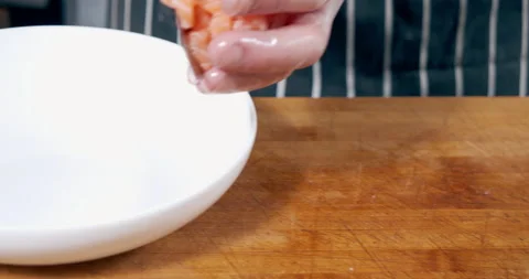 Close-up of a chef's hands in gloves slicing pieces of salmon and putting in a Stock Footage 152988297