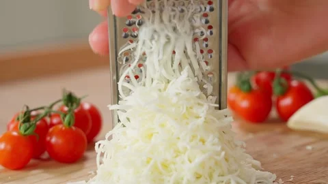 Close-up of a chef's hands grating mozzarella on a fine grater Stock Footage 266317747