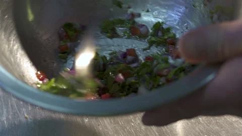 Close-up of the chef's hands holding an iron bowl and stirring vegetables. Stock Footage 153383444