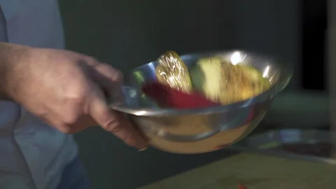 Close-up of the chef's hands holding an iron bowl and stirring the vegetables Stock Footage 153383708