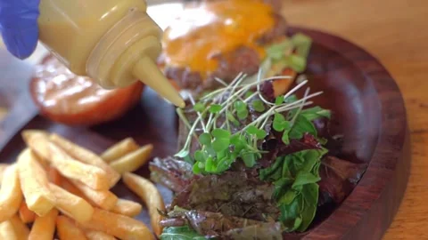 Close-up of chef's hands pouring sauce on salad, slow motion video, high quality Stock Footage 228685048