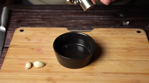 Close up of a chef's hands pressing garlic with a garlic press. Video stock 301442676