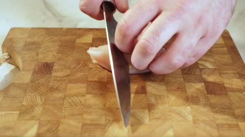 Close up of a chef's hands slicing chicken breasts. Slow motion video. Stock Footage 239159709
