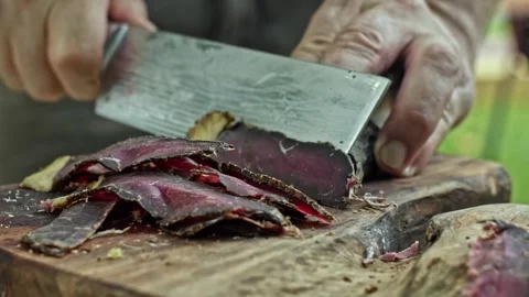 Close up of chef's hands slicing a cooked brisket on wooden tray  at the park Stock Footage 278616947