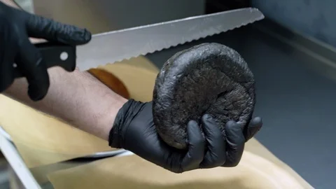 Close up of chef's hands slicing in half a burger bun Stock Footage 115840950