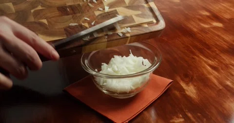Close-up of a chefs hands transferring chopped fresh white onions, coarsely Stock Footage 317722537