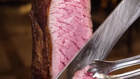 Close-up of a Chef's Knife Slicing Into a Perfectly Cooked, Juicy Picanha Steak Video stock 332813065