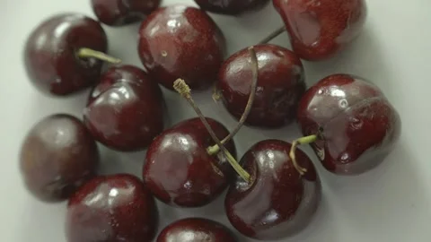 Close up to cherries spinning on a white plate Stock Footage 272283202
