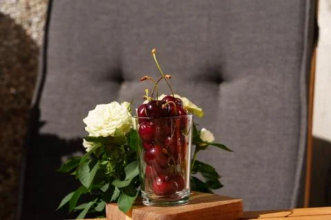 A close-up of a cherry being picked up from a wooden stand in an outdoor ga.. Photos