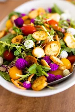 Close-up of cherry tomatoes, bread slices and leaf vegetables salad served in Stock Photos
