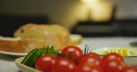 Close-up of cherry tomatoes, sliced cucumber, white bread and lemon on a table. 스톡 동영상 310736893