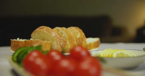 Close-up of cherry tomatoes, sliced cucumber, white bread and lemon on a table. Video stock 310736896