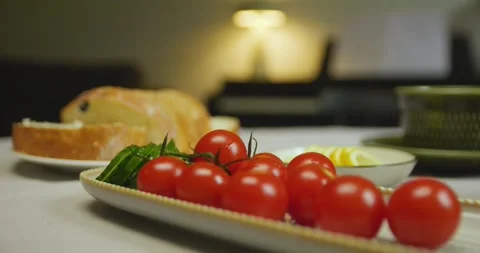 Close-up of cherry tomatoes, sliced cucumber, white bread and lemon on a table. Video stock 310736926