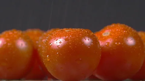 Close-up of cherry tomatoes sprinkled with water and rotating on a plate Stock Footage 60192420