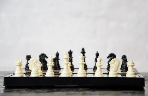 Close-up of chess pieces placed on chessboard at beginning of the game. Conce Stock Photos