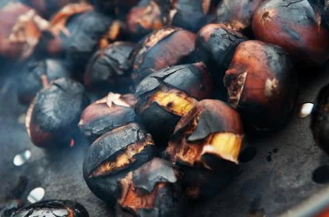 Close-up of chestnuts roasting in a pan on open fire Stock Photos