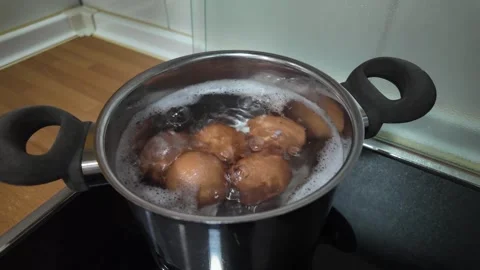 Close-up of chicken eggs boiling in stainless pan with hot water and bubbles Stock Footage 337286965