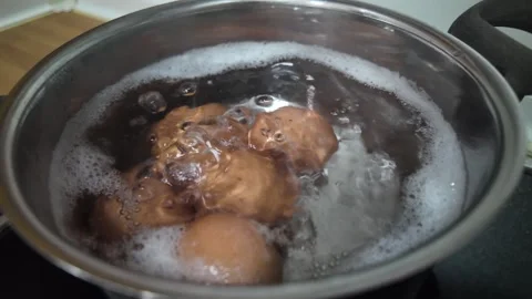 Close-up of chicken eggs boiling in stainless pan with hot water and bubbles Stock Footage 337286969