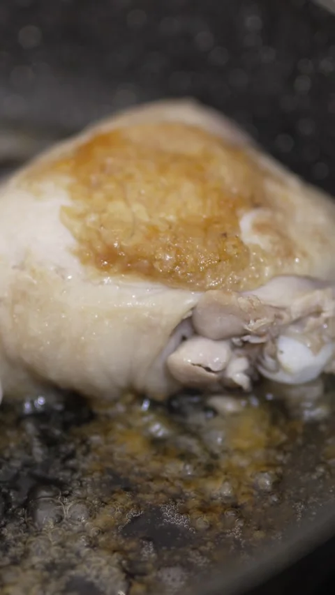 Close-up of chicken thighs sizzling and browning in a pan Stock Footage 333701145