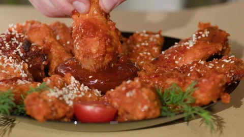 Close up. Chicken Wing is Dipped into a Ketchup Bowl on a Table. Stock-Footage 247723083