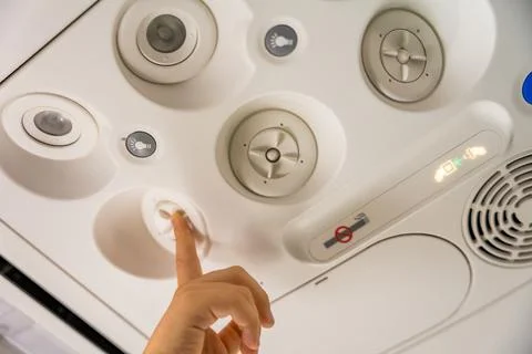 Close up of a child adjusting the overhead panel on an airplane Stock Photos