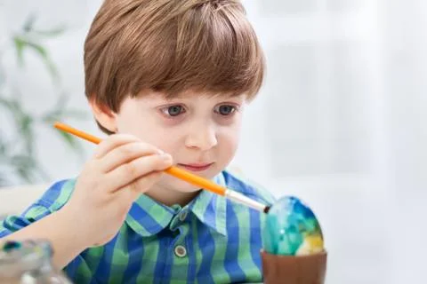 Close up of child boy coloring easter egg Stock Photos