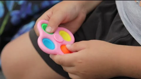 Close-up child boy hands playing with popular silicone anti-stress toy pop it  Stock Footage 159945562