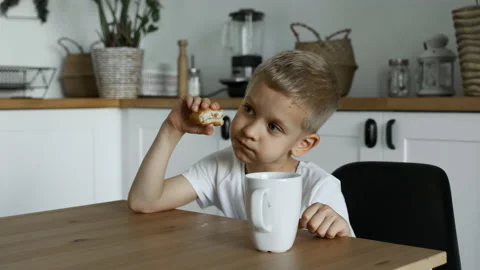 Close-Up of A Child Boy Having Lunch, Eating A Pie and Drinking Tea Stock Footage 156847407