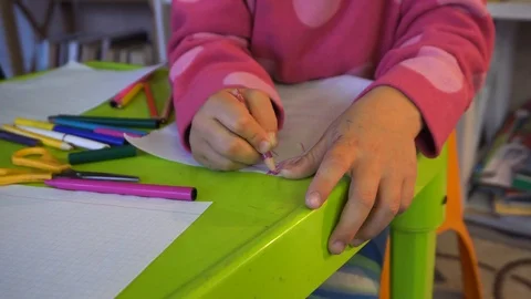 Close up of a child coloring with a crayons on a table. Child hands paints  Stock Footage 98694696