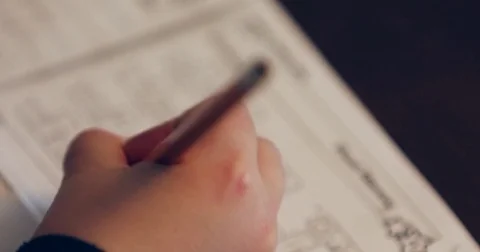 Close up of child doing homework and studying shot from above Vidéo 72759588