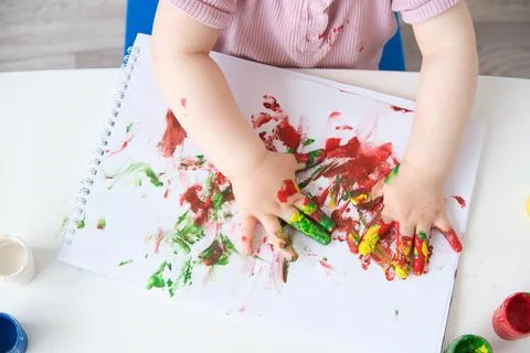 Close up child is drawing on white sheets with finger paints Stock Photos