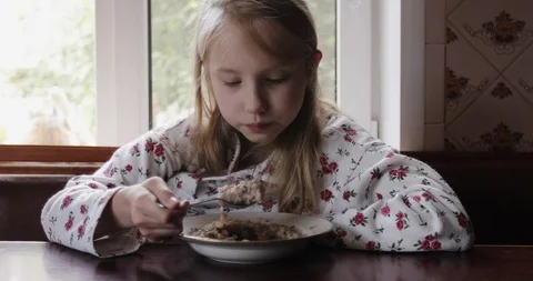 Close up of child girl face while she eats porridge. Stock Footage 118654185