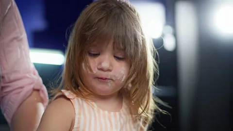 A close-up of a child, a girl whose face is covered in flour Vidéo 240020595
