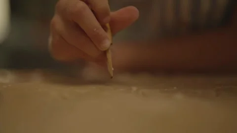 Close-up of child hand drawing shape in dough with spatula 库存影片 336374657