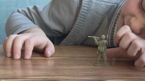 Close Up Child Hand Moving Toy Soldier On Wooden Table Playing War Game Stockbeeldmateriaal 336321300