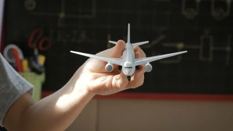 Close up of child hand playing with plane toy in school class. Stock-Footage 77819698