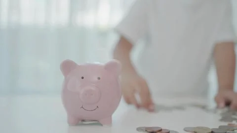 Close-up of a child hand throwing coins into piggy bank piggy bank coins co.. Stock Footage 265935343