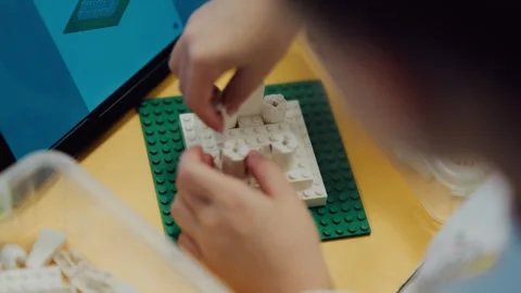 Close up of child hands choosing plastic interlocking bricks from container, Stock Footage 345138209
