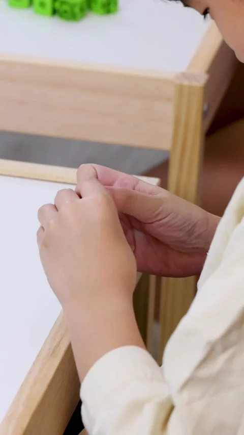Close Up of Child Hands Connecting Purple Math Cubes at Desk Stock Footage 331899053