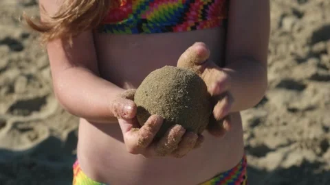 Close up of child hands holding wet round sand ball on beach Vídeos de archivo 339285906