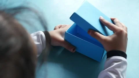 Close up of child hands opening empty blue gift box on turquoise background. Stock Footage 333033894