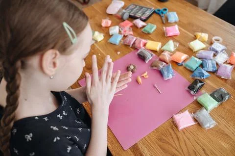 Close up of child hands sculpting at table with colorful pieces of modeling.. Stock Photos