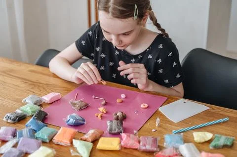 Close up of child hands sculpting at table with colorful pieces of modeling.. Stock Photos