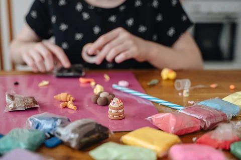 Close up of child hands sculpting at table with colorful pieces of modeling.. Stock Photos