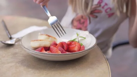 Close-up, the child has a breakfast of cottage cheese and strawberries in the Stock Footage 222811742